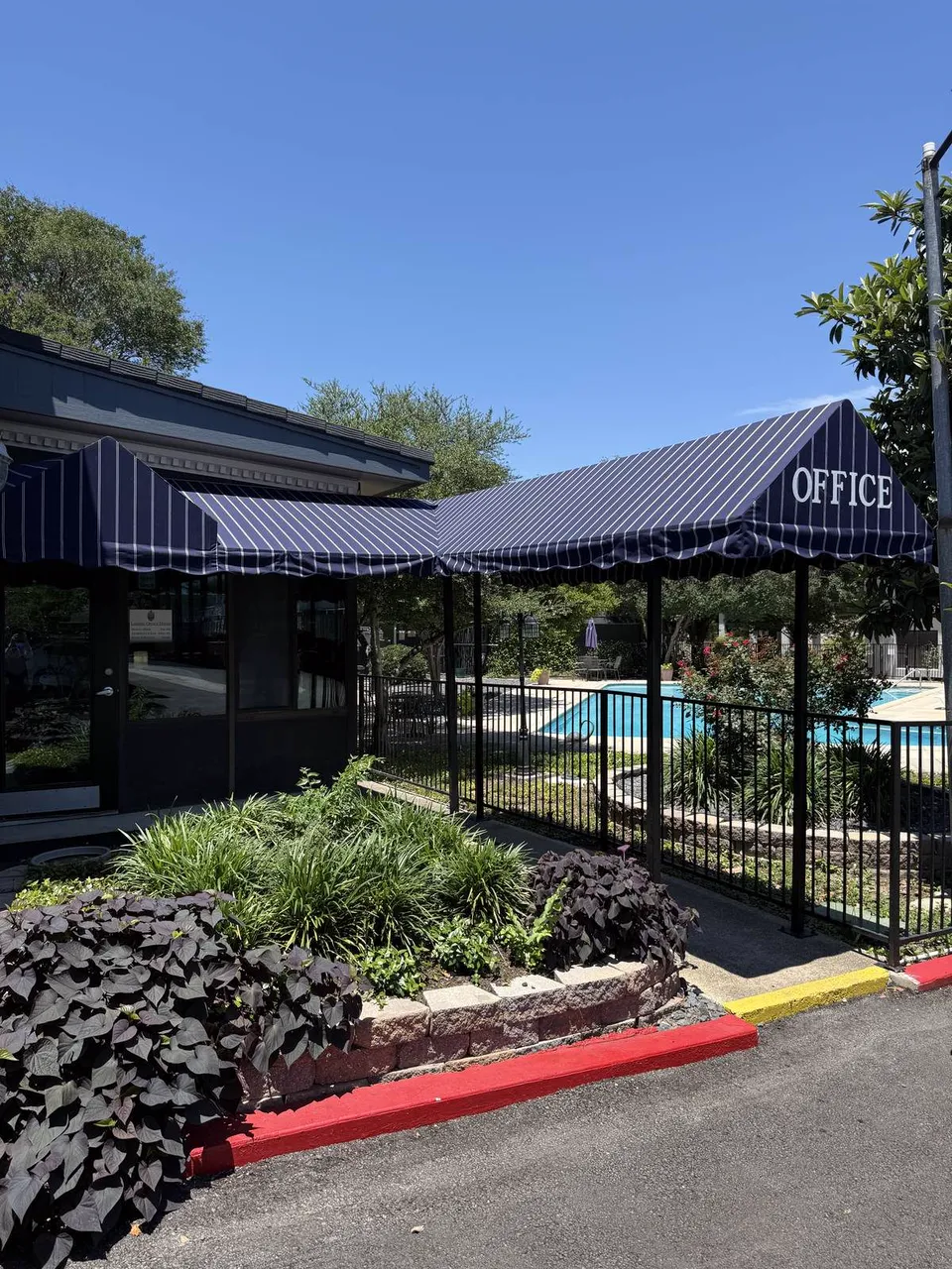 Leasing office entrance with awning at Wilshire Woods Apartments