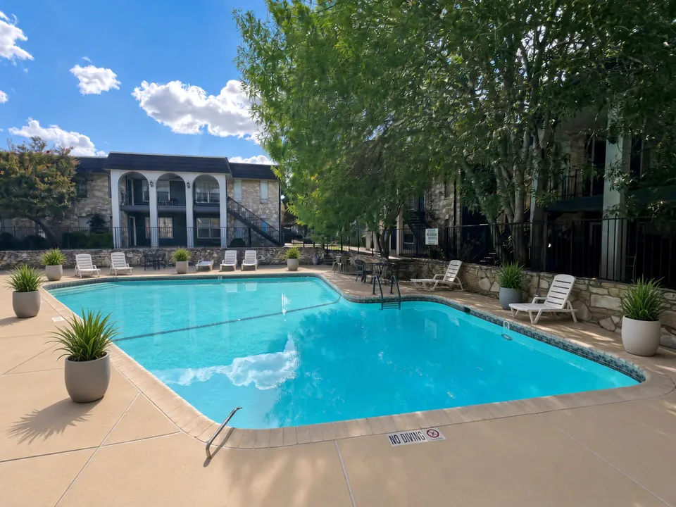 Second swimming pool bordered by a stone wall at Wilshire Woods Apartments